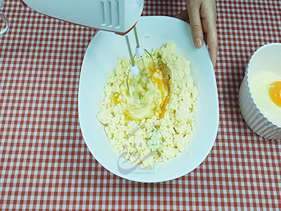مخلط کردن تخم مرغ با مواد برای تهیه شیرینی کشمشی